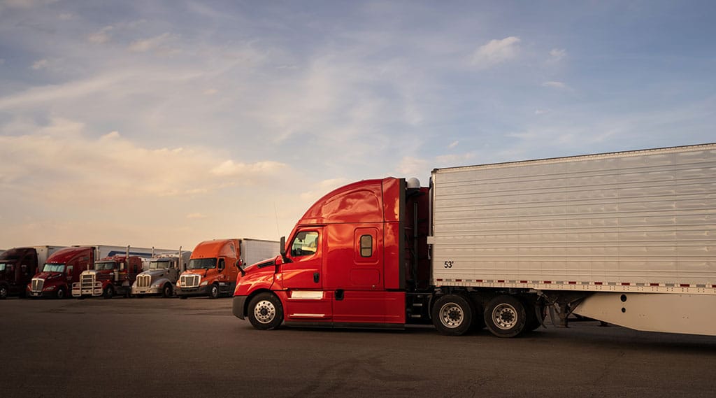 red semi trailer pulling into lot